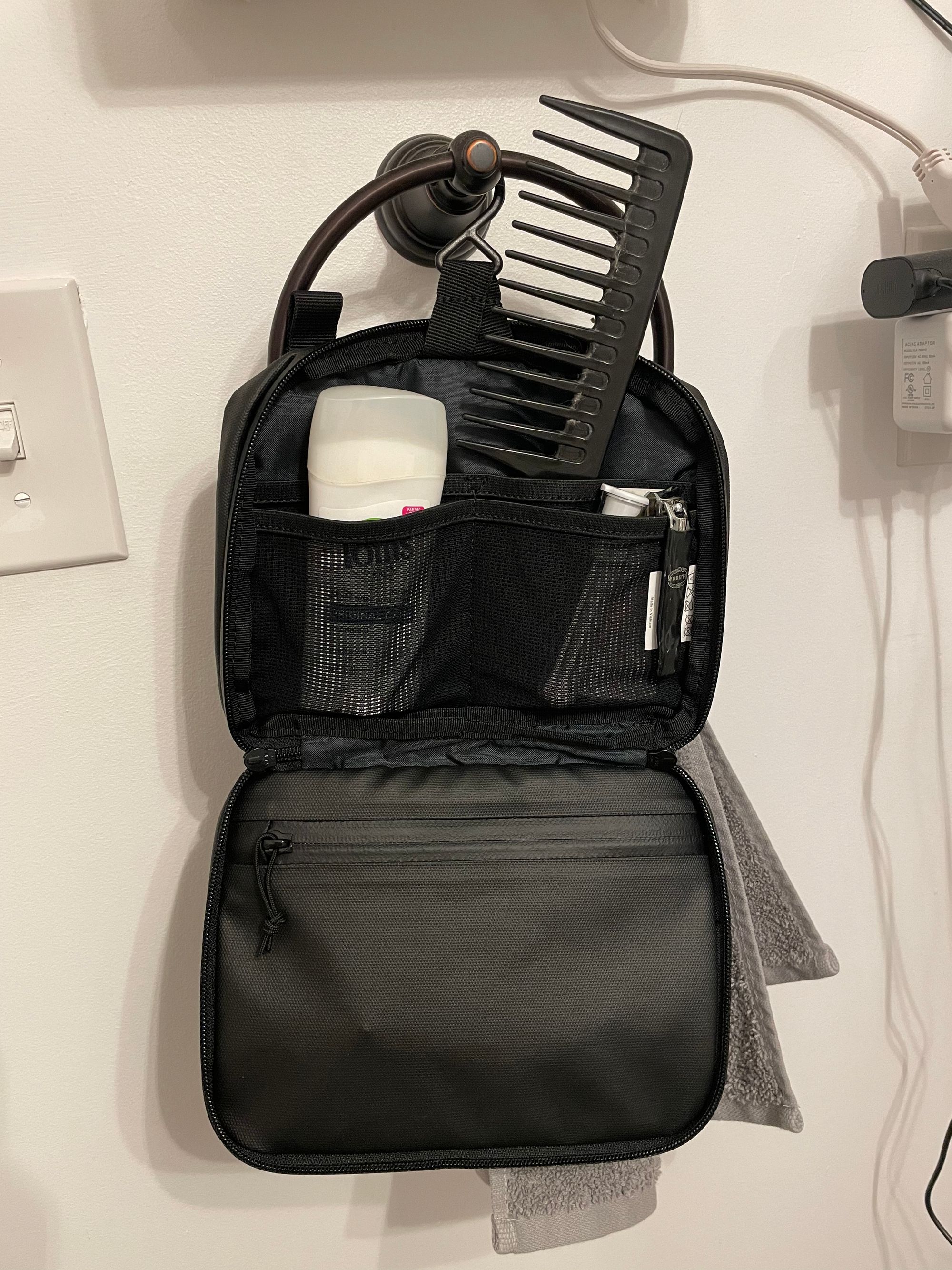 A small toiletry bag hangs on a hook. Deodorant and a comb are visible.