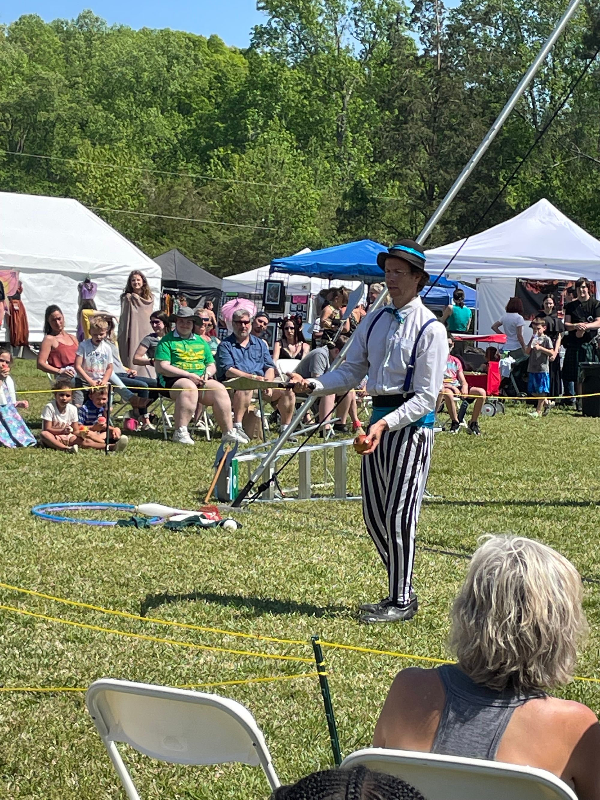 A juggler with two knives and an apple.