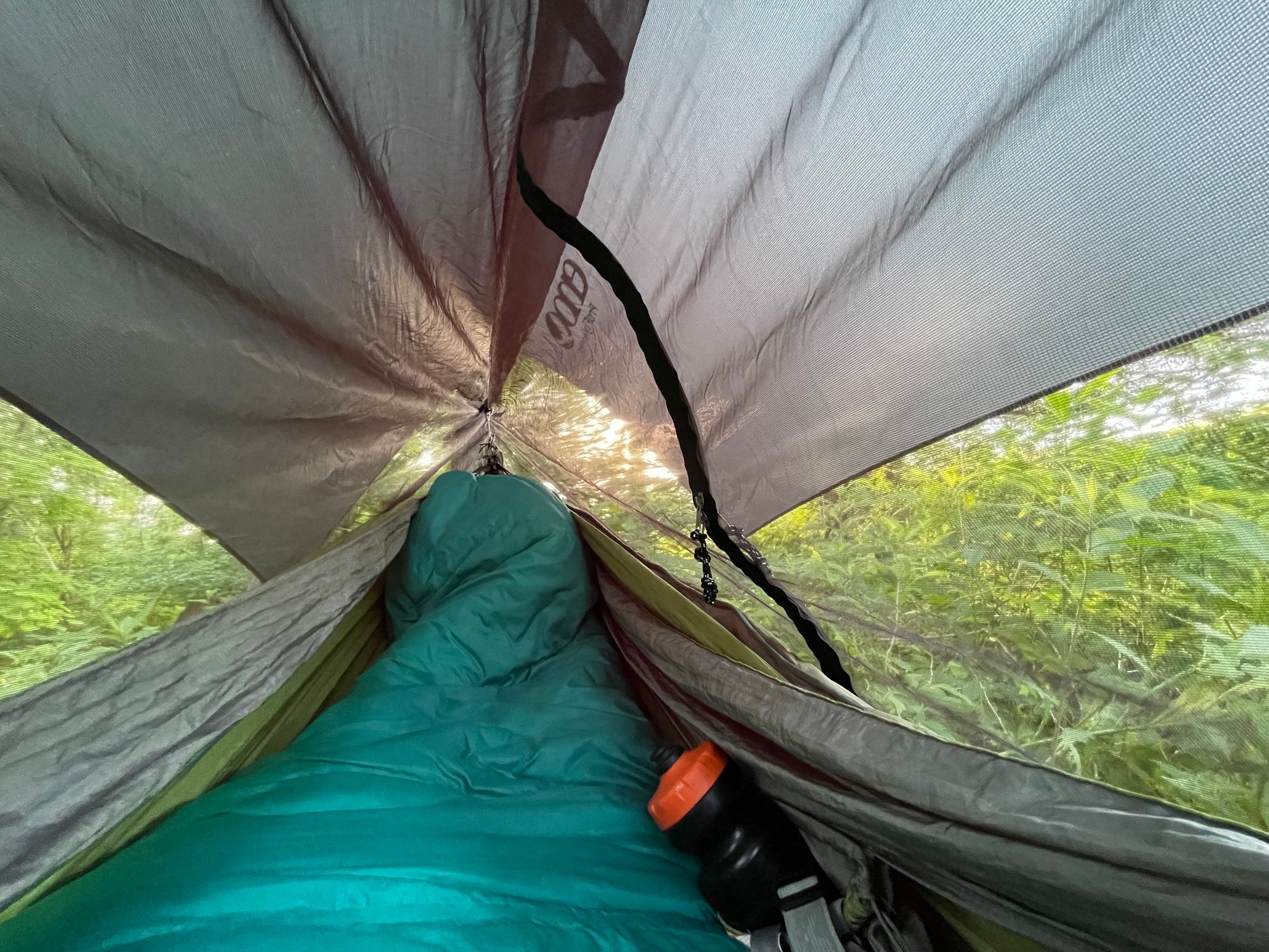POV from the hammock. There's a bug net and rainfly overhead and my feet and legs are in the sleeping bag. There's a water bottle tucked in, too.