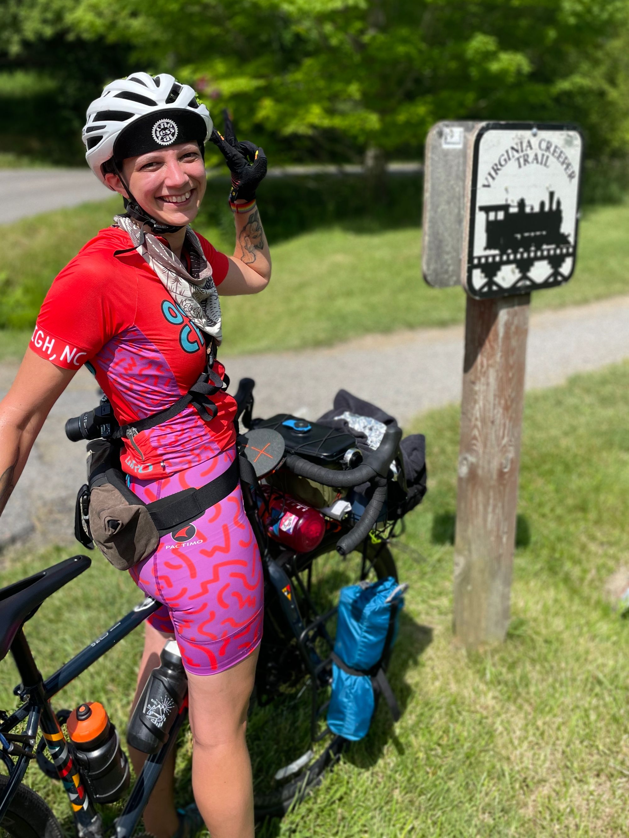 Autumn standing over her bike in front of a Virginia Creeper Trail sign.